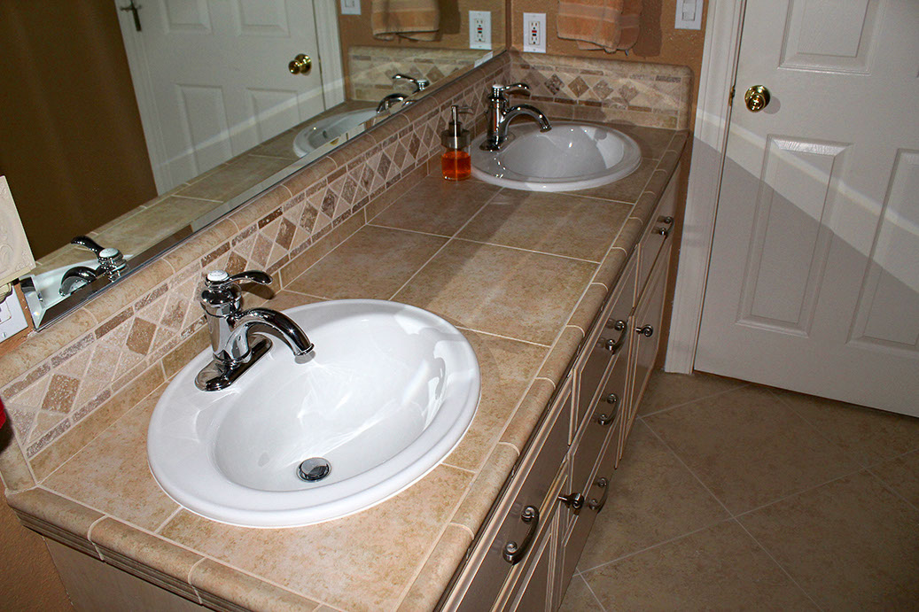 Gorgeous stone tile work in bathroom counter and backsplash by Rock Solid Creations.