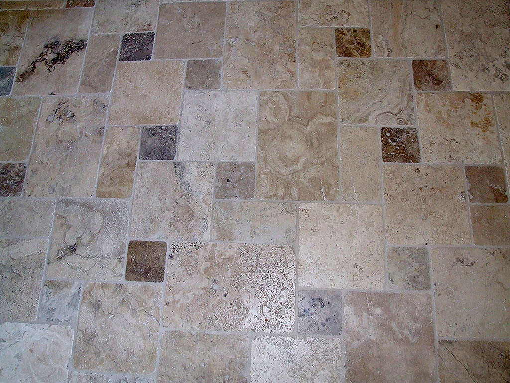 Mixed sizes and colors of stone floor tiles, installation in California.