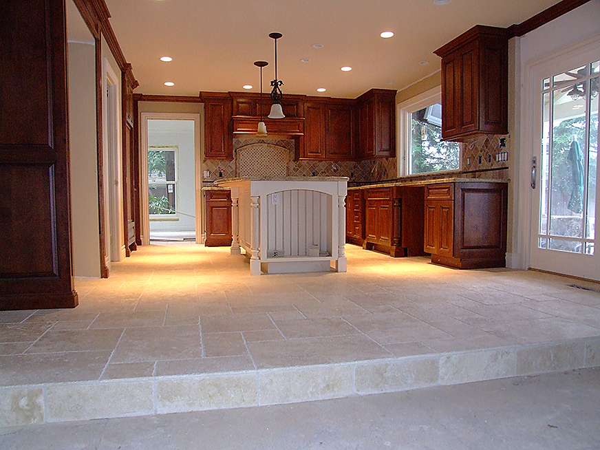 Marble stone floor tile installation in kitchen and dining room. Stone countertops and backsplashes in kitchen.