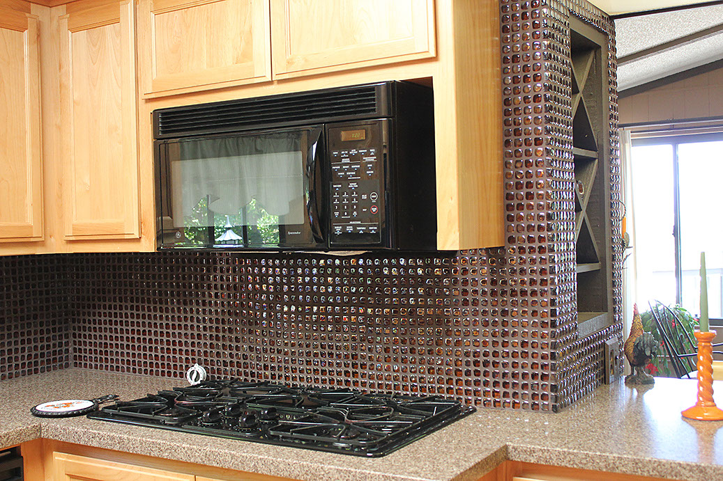 Mini glass tiles used on wall in kitchen. Granite countertop custom installation.